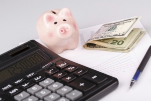 piggy bank and calculator on a desk
