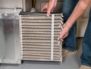 Person replacing their heating system filter