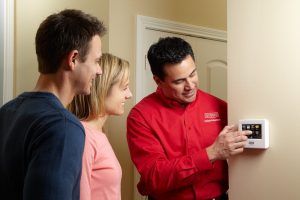 Couple learning how to use a thermostat