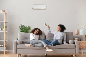 mother and daughter on couch using ductless heating unit